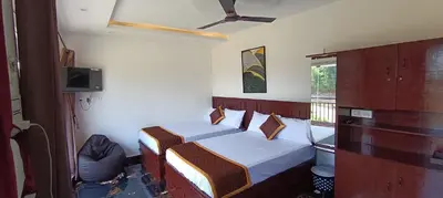 a bedroom with two beds and a tv and a window at Glasshouse Retreat by The Jungle stay groups in Vālpārai