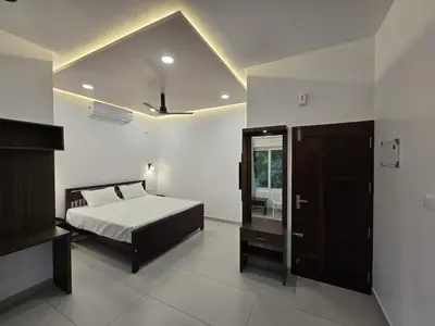 a bedroom with a bed and a mirror at Sea Breeze Cherai Homestay in Pallipuram