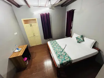 a small room with a bed and a door at ERA Heritage Inn in Kozhikode
