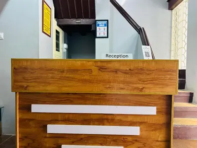 a wooden dresser in front of a stair case at ERA Heritage Inn in Kozhikode