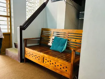 a wooden bench with a blue pillow on a staircase at ERA Heritage Inn in Kozhikode