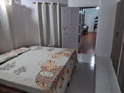 a bedroom with a bed with a quilt on it at Fireflies R in Madikeri