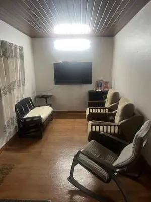 a living room with couches and a flat screen tv at Fireflies R in Madikeri
