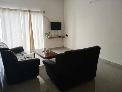 a living room with two chairs and a table at Temple Bells in Mysore