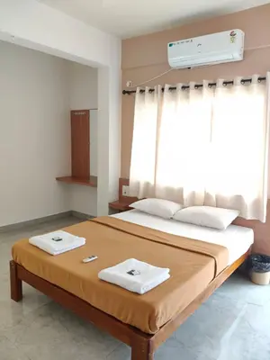 a bedroom with a large bed with two towels on it at Temple Bells in Mysore