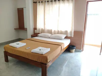 a bedroom with a bed with two towels on it at Temple Bells in Mysore