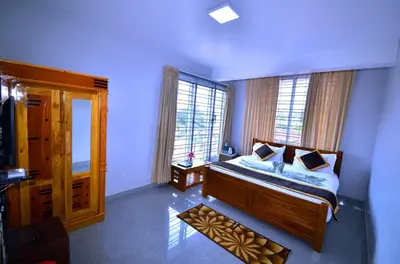 a bedroom with a bed and a large window at Cute Corner Homestay,Ooty in Ooty