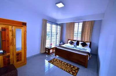 a bedroom with a bed and two windows at Cute Corner Homestay,Ooty in Ooty