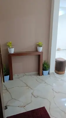 a room with a table with potted plants on it at Eve Service apartment in Mysore