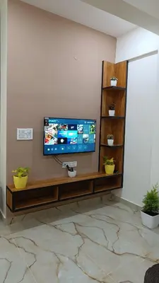 a flat screen tv sitting on a wall in a living room at Eve Service apartment in Mysore