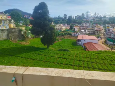 a view of a village with a green field at Ooty mountain Cottage in Ooty