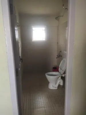 a bathroom with a toilet and a window at Ooty mountain Cottage in Ooty