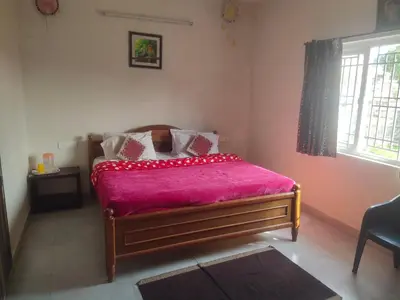 a bedroom with a bed with a pink blanket at Ooty mountain Cottage in Ooty