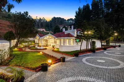 a large house with a courtyard with lights at Tiverton Bungalow in Ooty