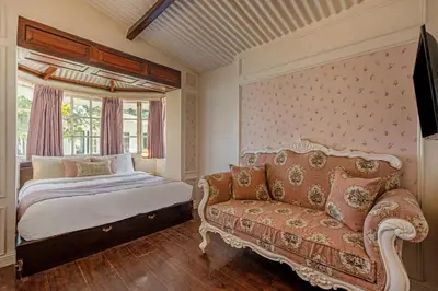 a bedroom with a bed and a couch at Tiverton Bungalow in Ooty