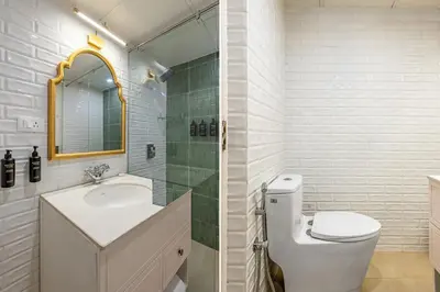 a bathroom with a toilet and a sink and a mirror at Tiverton Bungalow in Ooty
