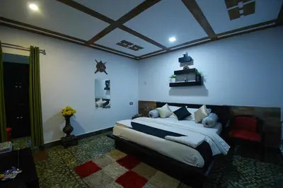 a bedroom with a bed and a red chair at Green Leaves The Countryside Inn in Ooty