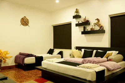 a living room with two beds and a couch at Green Leaves The Countryside Inn in Ooty