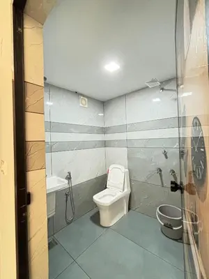 a bathroom with a toilet and a shower and a sink at GRAYSTONE HOMESTAY, Omassery in Tāzhekkod