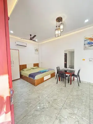 a bedroom with a bed and a table and chairs at GRAYSTONE HOMESTAY, Omassery in Tāzhekkod