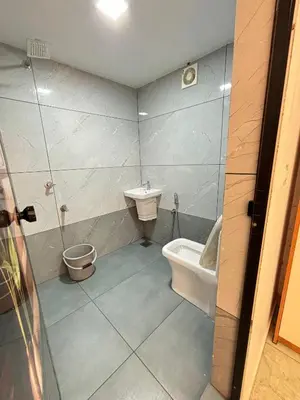 a bathroom with a toilet and a sink at GRAYSTONE HOMESTAY, Omassery in Tāzhekkod