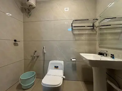 a bathroom with a toilet and a sink at Wayanad Vista Palm View Homes in Padinjarathara