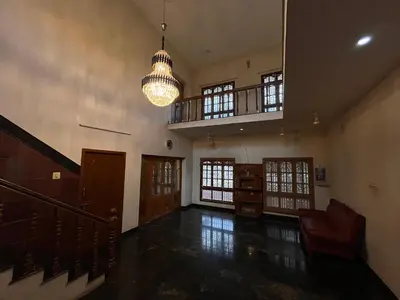 a large room with a staircase and a chandelier at Vasantham Home Stay in Satyamangalam