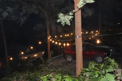 a car parked next to a pole with lights at Cicadas Nature Resort - A Frame cottages in Wayanad