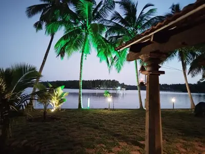 a view of a body of water with palm trees at whispering waters in Kozhikode