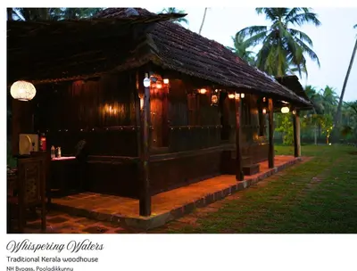 a small wooden building with a table in the grass at whispering waters in Kozhikode