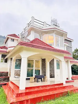 a house with a red roof with a bench on it at BR Villa in Kodaikānāl