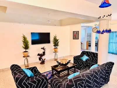 a living room with two couches and a tv at BR Villa in Kodaikānāl