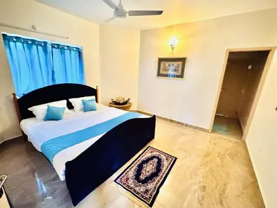 a bedroom with a large bed with blue pillows at BR Villa in Kodaikānāl