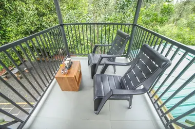 two chairs and a coffee table on a balcony at Valley View by Xploreindo in Pandalūr