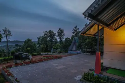 a building with a pavilion and a flower garden at Valley View by Xploreindo in Pandalūr