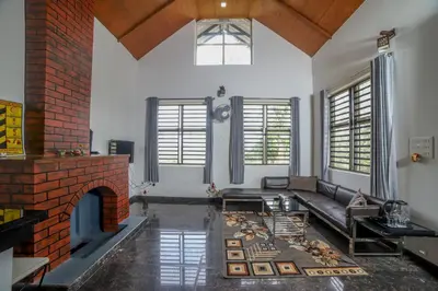 a living room with a couch and a fireplace at Valley View by Xploreindo in Pandalūr