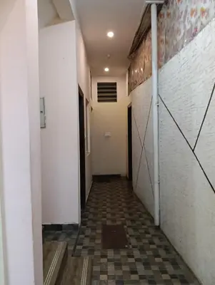 an empty hallway with a tile floor and white walls at MM comforts in Mysore