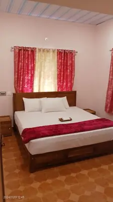 a bedroom with a large bed with red curtains at Diamond Villas Wayanad Entire Villa booking in Mananthavady