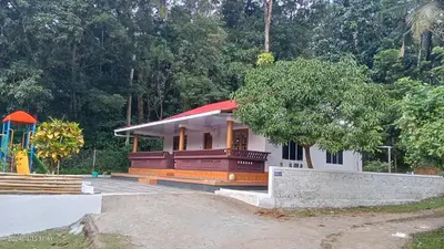 a small house with a tree and a playground at Diamond Villas Wayanad Entire Villa booking in Mananthavady