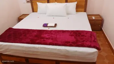 a bedroom with a white bed with a purple blanket on it at Diamond Villas Wayanad Entire Villa booking in Mananthavady