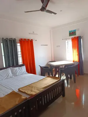 a bedroom with a bed and a table with chairs at Dam Valley Home Stay Resort in Parambikolam
