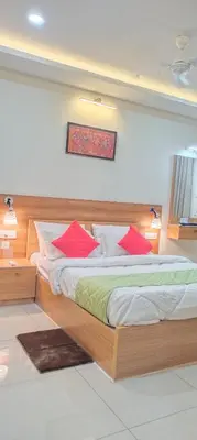 a bedroom with a large wooden bed with red pillows at Sree Nandhanam Apartment's in Guruvāyūr