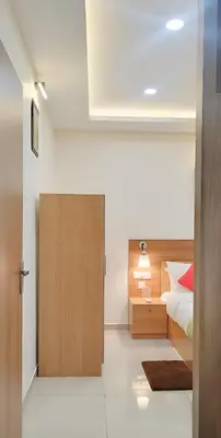 a bedroom with a bed and a wooden door at Sree Nandhanam Apartment's in Guruvāyūr