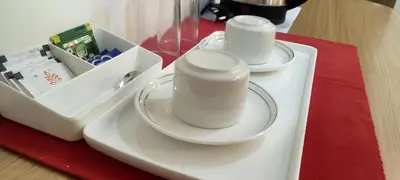 two white cups on a plate on a table at Sree Nandhanam Apartment's in Guruvāyūr