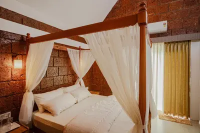 a bedroom with a canopy bed with white pillows at Misty Forest Resort Wayanad in Wayanad