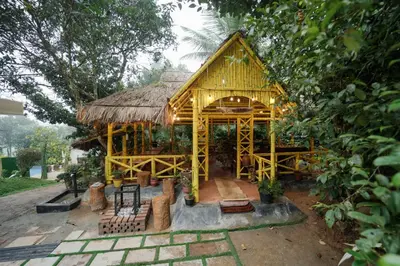 a small bamboo house with a thatched roof at Wayanad Vista Family Bungalow in Padinjarathara