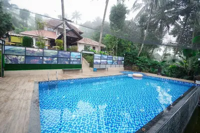 a large swimming pool in front of a house at Wayanad Vista Family Bungalow in Padinjarathara