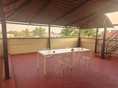 a white table and chairs in a room with windows at 6bhk Luxury Villa in Mysore