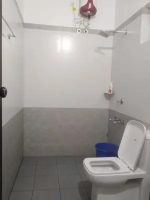 a bathroom with a white toilet and a blue trash can at 2BHK Flat At Chalakudy Town Konuparamban Residence A1 in Kizhake Chālakudi