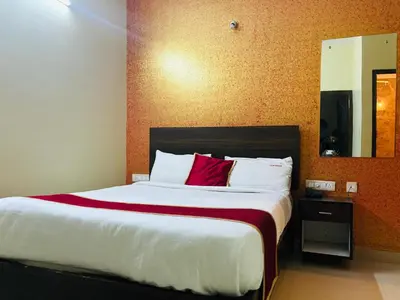 a bedroom with a large bed with a red pillow at Avini Stay in Mysore
